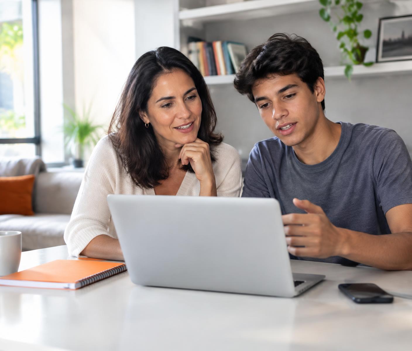 Mãe e adolescente conversam enquanto usam um notebook em casa